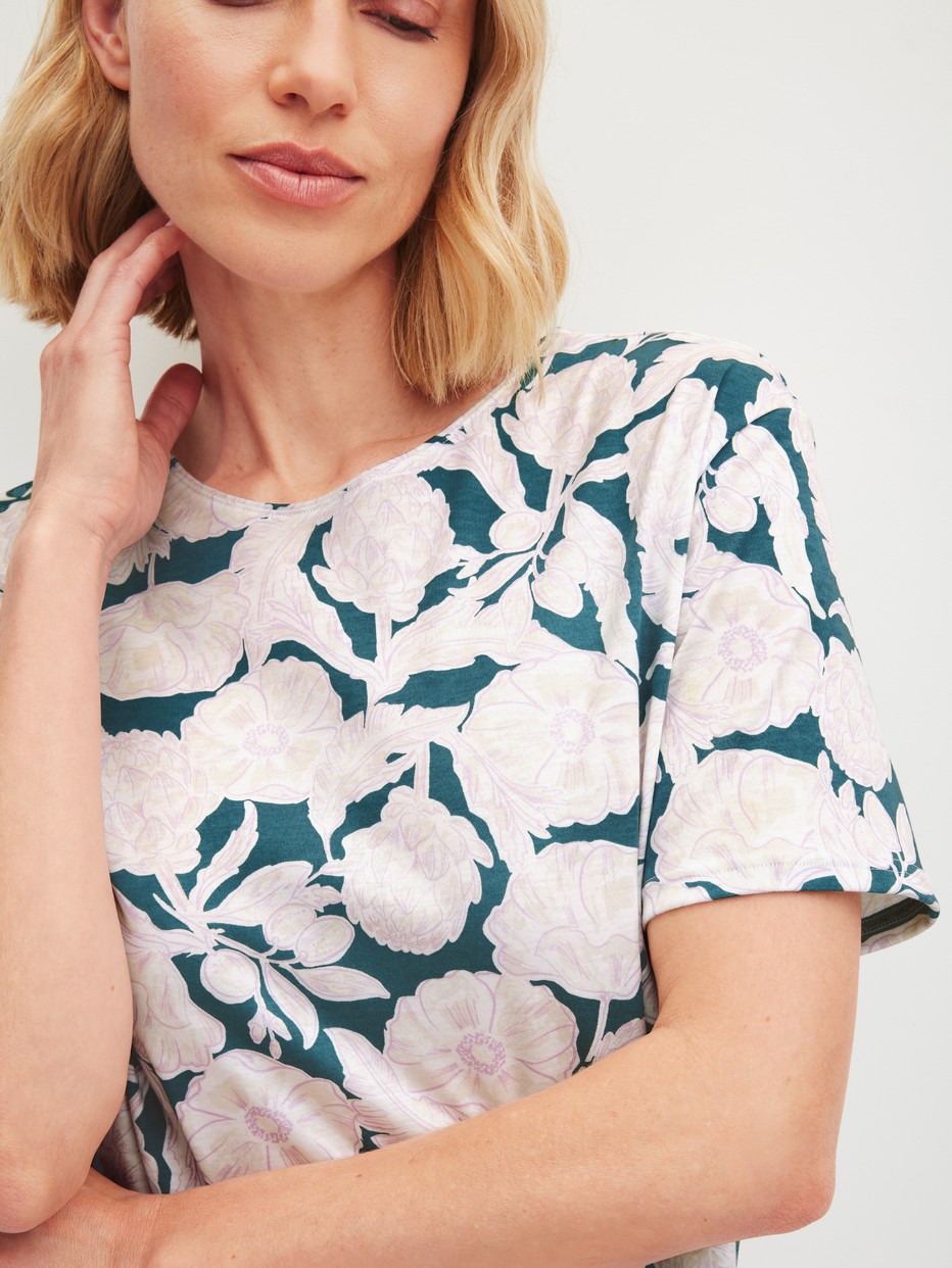 Women model is wearing Short-sleeved nightdress, length 95 cm made of 100% Cotton in Turquoise, Floral from the Botanic Dreams series by CALIDA, Detail