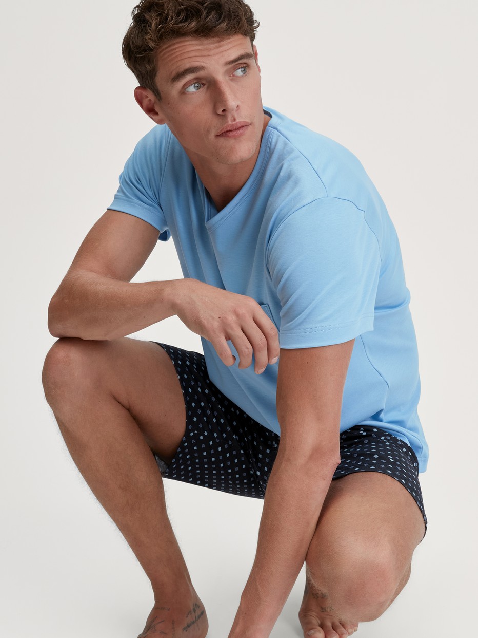 Men model is wearing Short pyjama made of 100% Cotton in Blue, Patterned from the Relax Streamline series by CALIDA, Front view