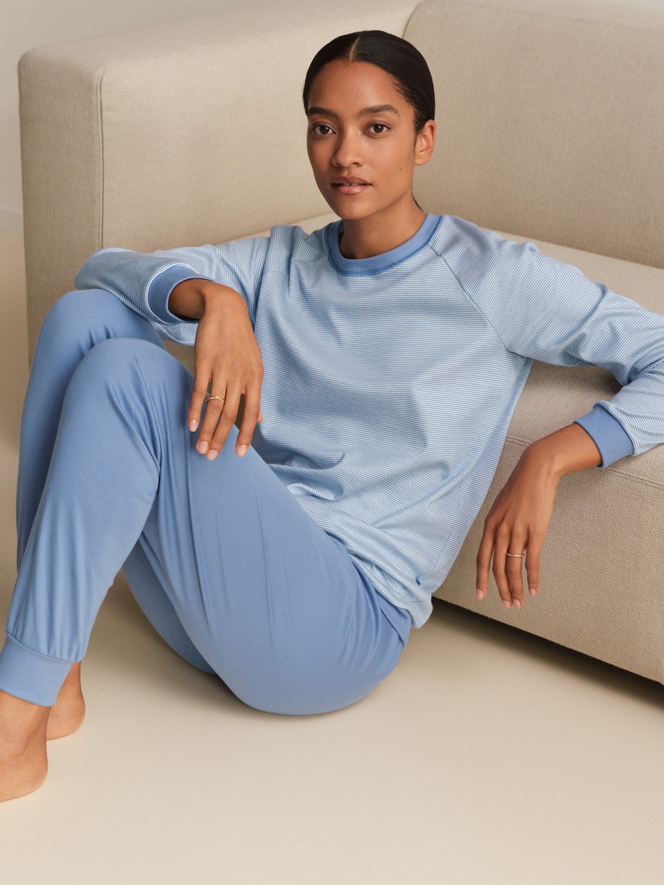 Damen-Model trägt Bündchen-Pyjama aus 100% Baumwolle in Blau, Gestreift aus Serie Midnight Stripes von CALIDA, Vorderansicht