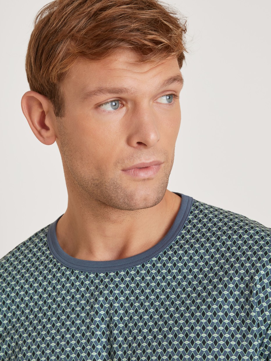 Herren-Model trägt Bündchen-Pyjama aus 100% Baumwolle in Blau, Motiv aus Serie Relax Enjoy von CALIDA, Detail