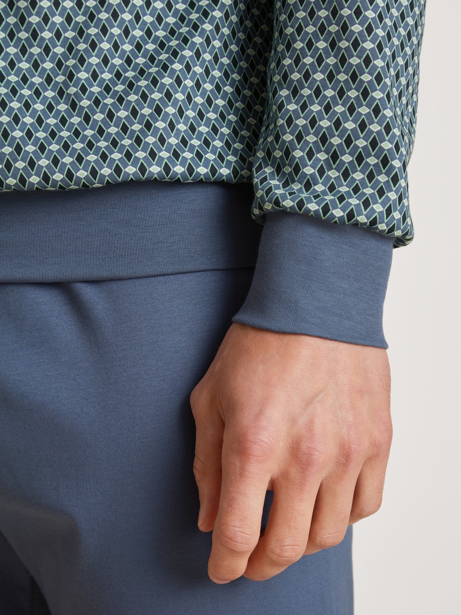 Herren-Model trägt Bündchen-Pyjama aus 100% Baumwolle in Blau, Motiv aus Serie Relax Enjoy von CALIDA, Detail
