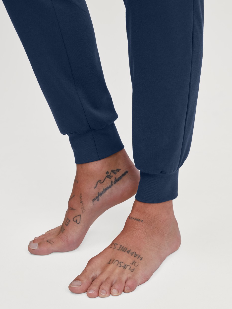 Herren-Model trägt Bündchen-Pyjama aus 100% Baumwolle in Blau, Motiv aus Serie Relax Ski Resort von CALIDA, Detail