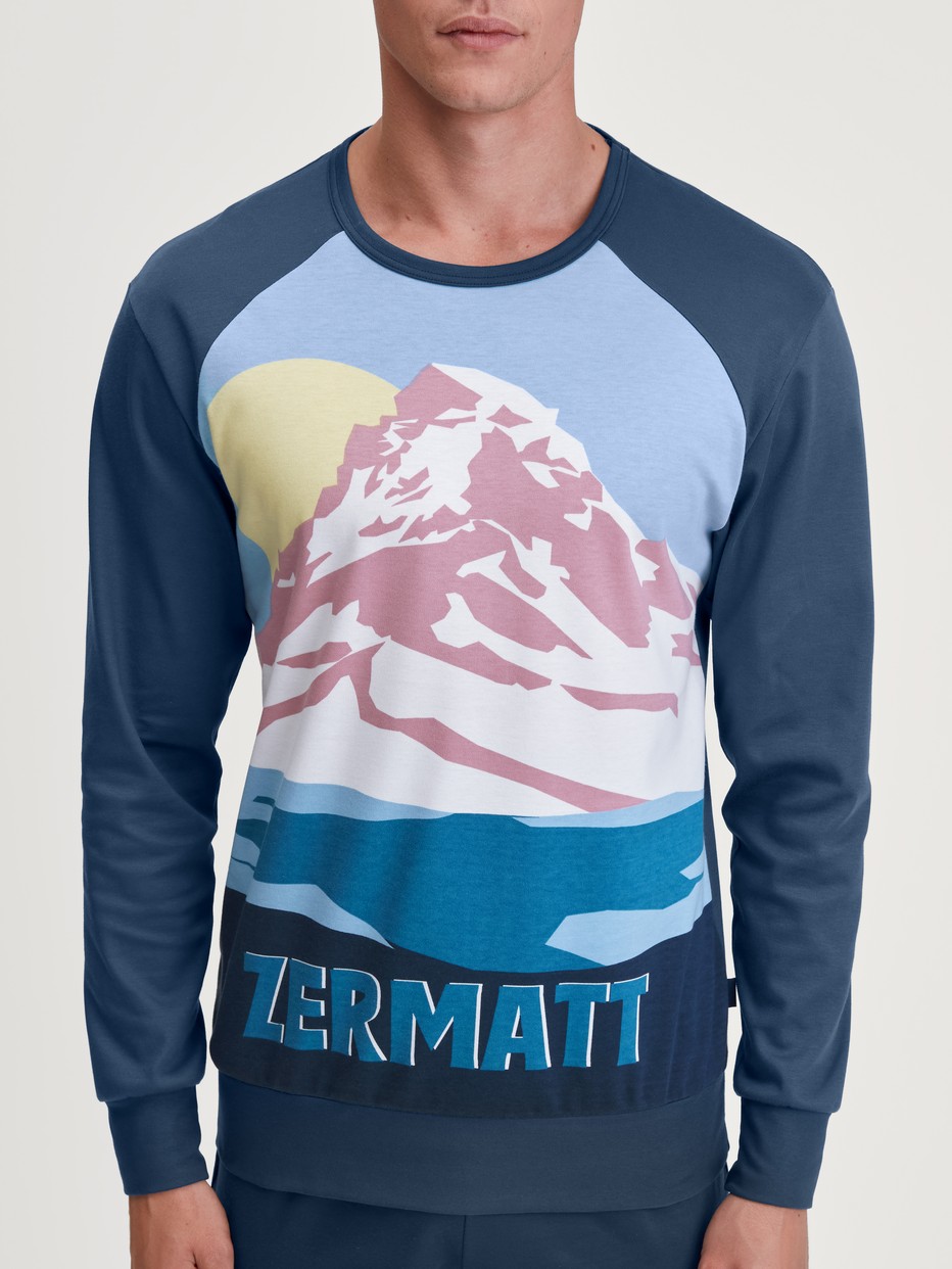 Herren-Model trägt Bündchen-Pyjama aus 100% Baumwolle in Blau, Motiv aus Serie Relax Ski Resort von CALIDA, Detail