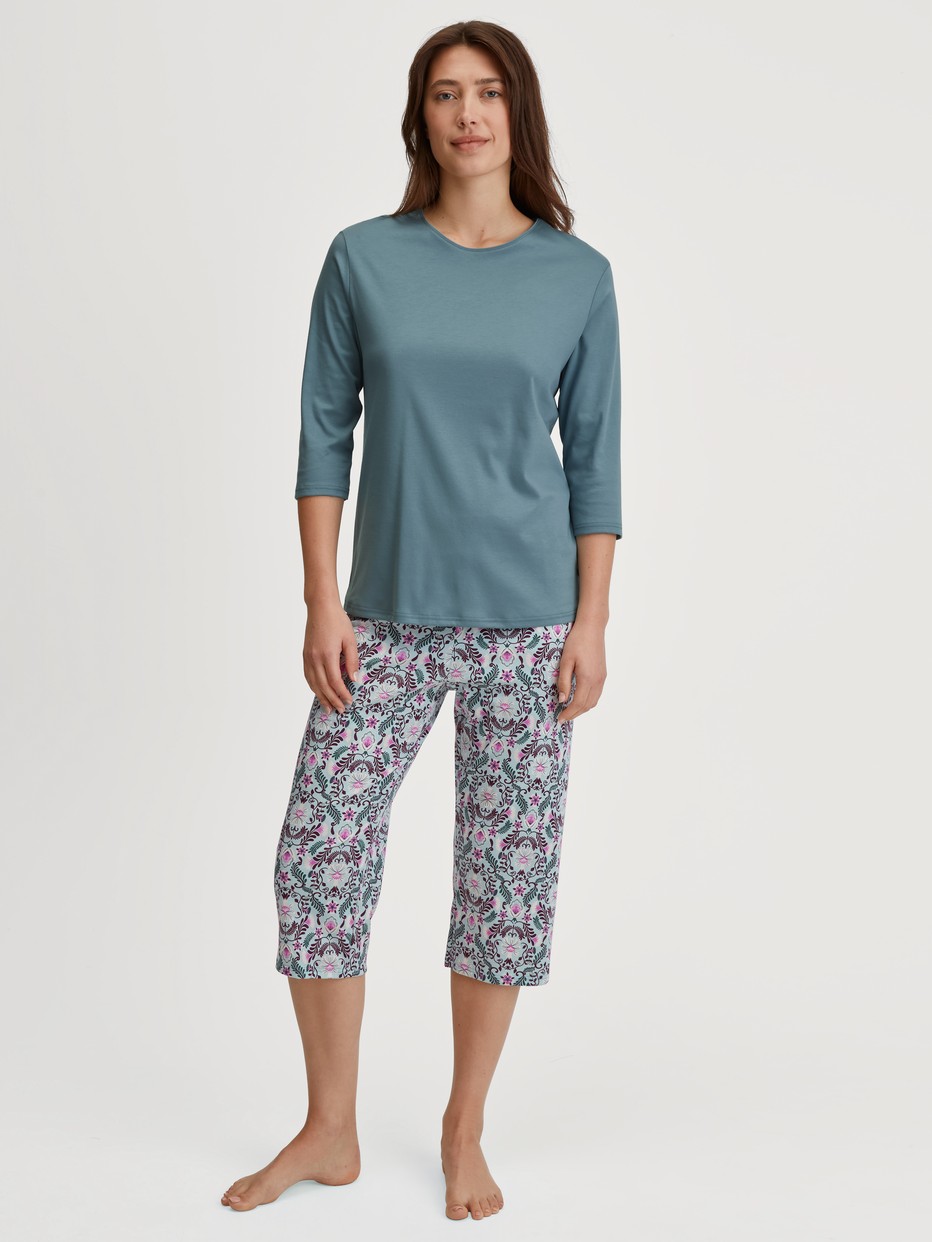 Women model is wearing Capri Pyjama made of 100% Cotton in Blue, Patterned from the Autumn Dreams series by CALIDA, Front view