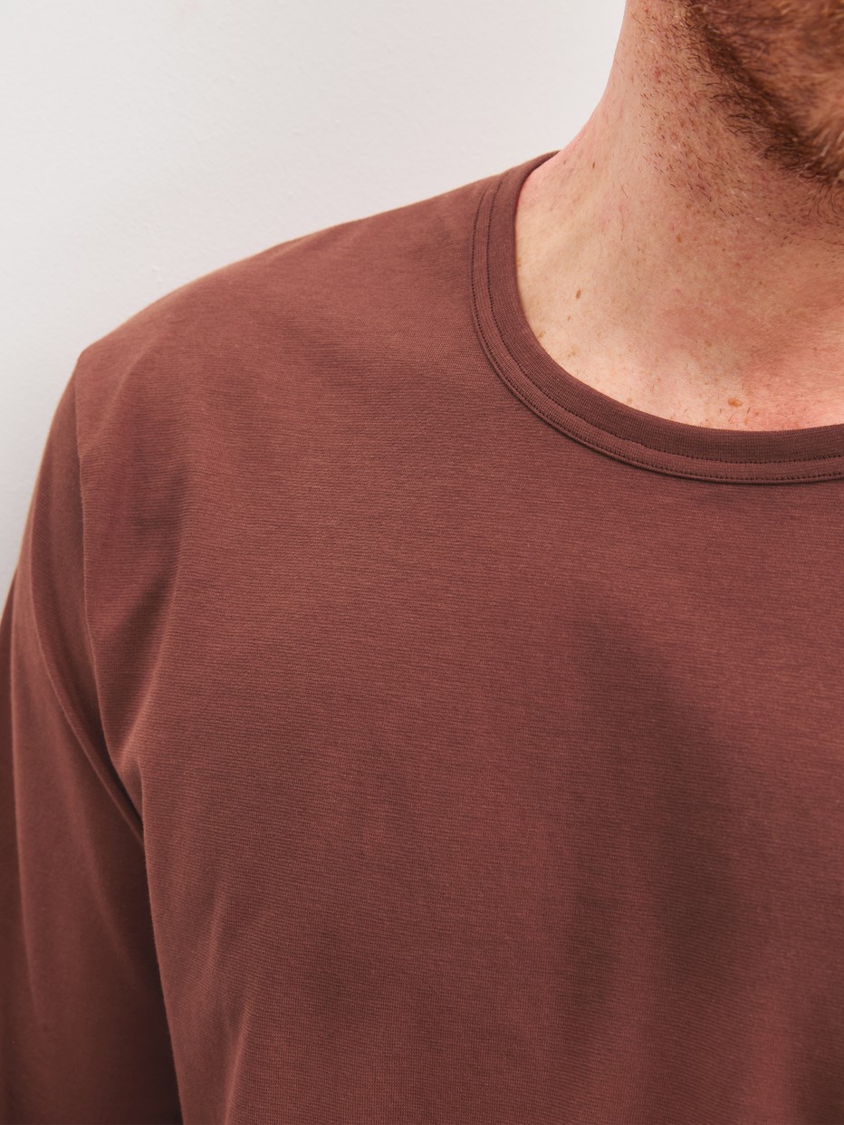 Herren-Model trägt Pyjama, lang aus 100% Baumwolle in Rot, Einfarbig aus Serie Relax Essentials von CALIDA, Detail