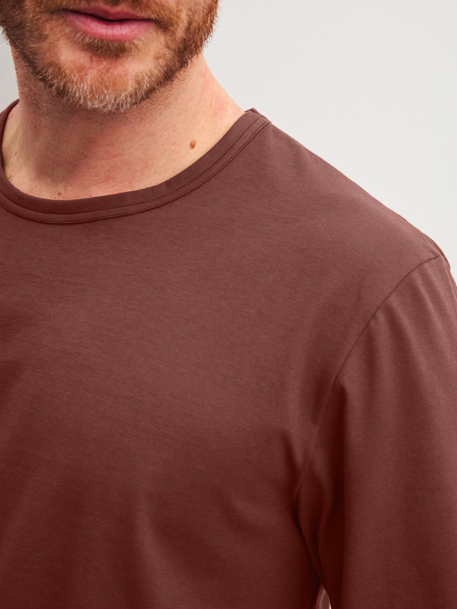 Herren-Model trägt Bündchen-Pyjama aus 100% Baumwolle in Rot, Einfarbig aus Serie Relax Essentials von CALIDA, Detail