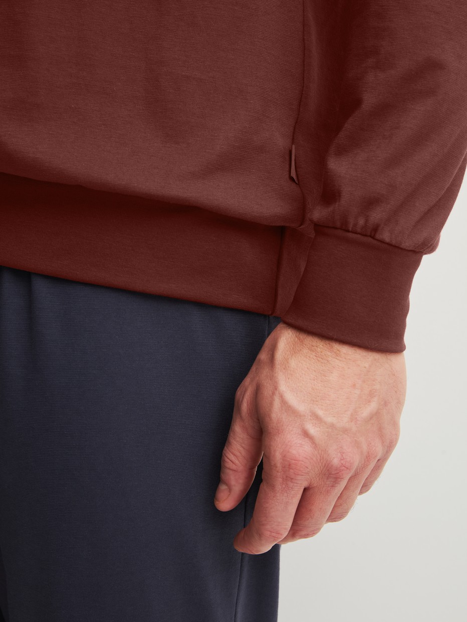 Herren-Model trägt Bündchen-Pyjama aus 100% Baumwolle in Rot, Einfarbig aus Serie Relax Essentials von CALIDA, Detail