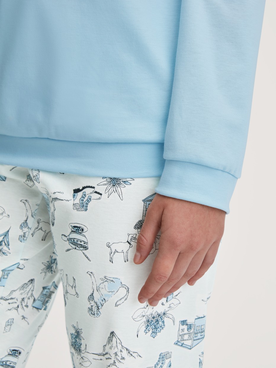 La modella / Il modello Donna indossa Pigiama con polsini in 100% cotone di colore Blu, Modello, della serie Swiss Resort di CALIDA, Dettaglio