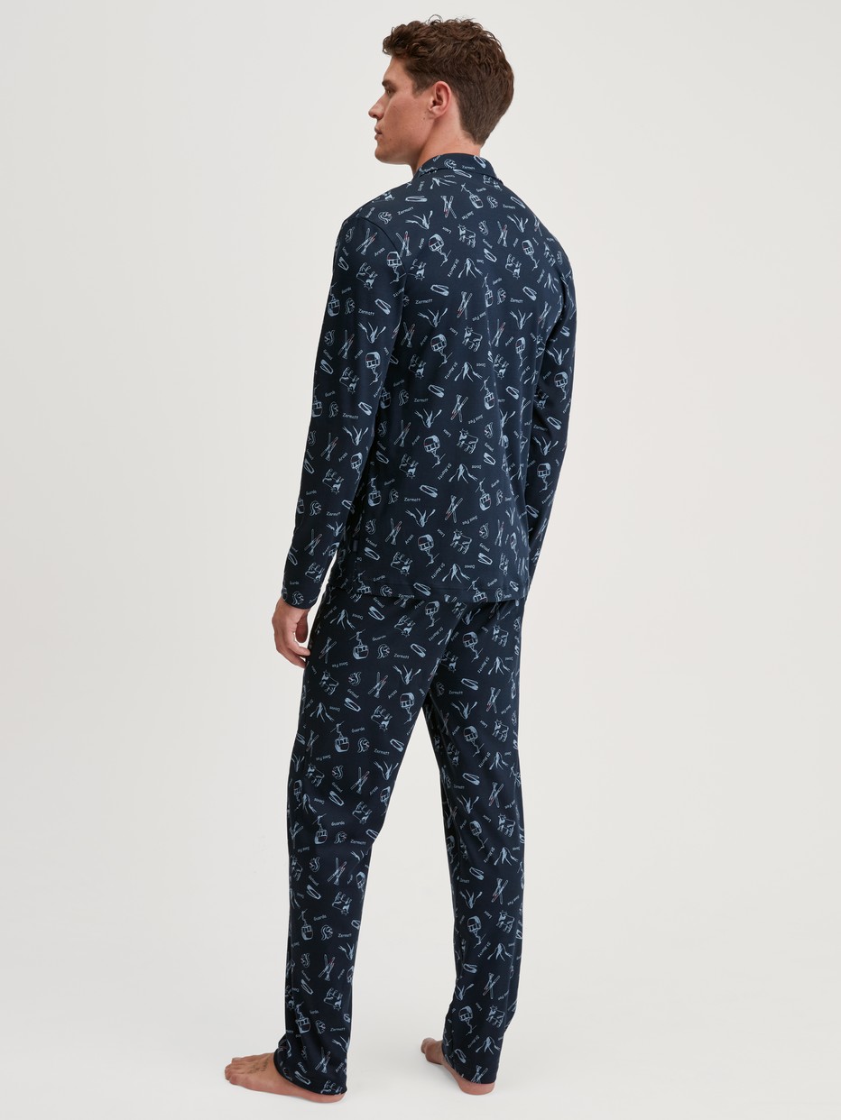 Men model is wearing Button-Up Pyjama made of 100% Cotton in Blue, Patterned from the Relax Swiss Resort series by CALIDA, Back view