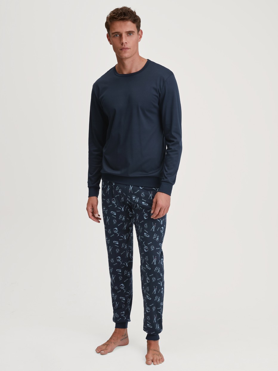 Men model is wearing Pyjama with cuff made of 100% Cotton in Blue, Patterned from the Relax Swiss Resort series by CALIDA, Front view