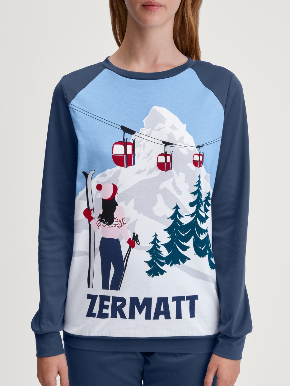 Damen-Model trägt Bündchen-Pyjama aus 100% Baumwolle in Blau, Motiv aus Serie Ski Resort von CALIDA, Detail