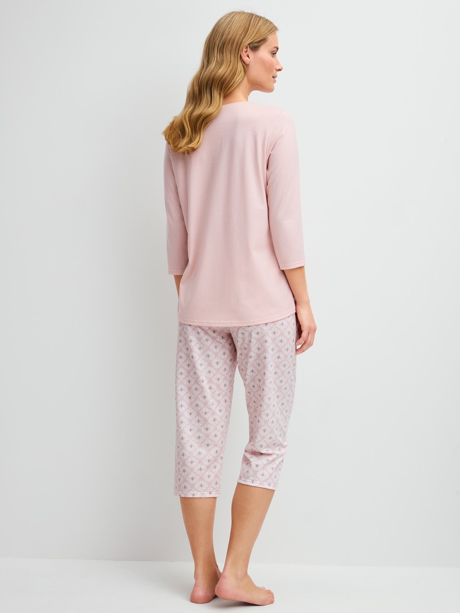 Damen-Model trägt Capri-Pyjama aus 100% Baumwolle in Rosa, Floral aus Serie Cotton Special von CALIDA, Rückansicht