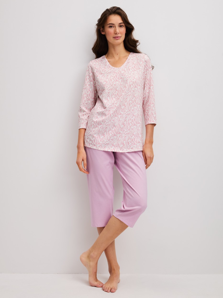 Damen-Model trägt Capri-Pyjama aus 100% Baumwolle in Violett, Gemustert aus Serie Blooming Nights von CALIDA, Vorderansicht