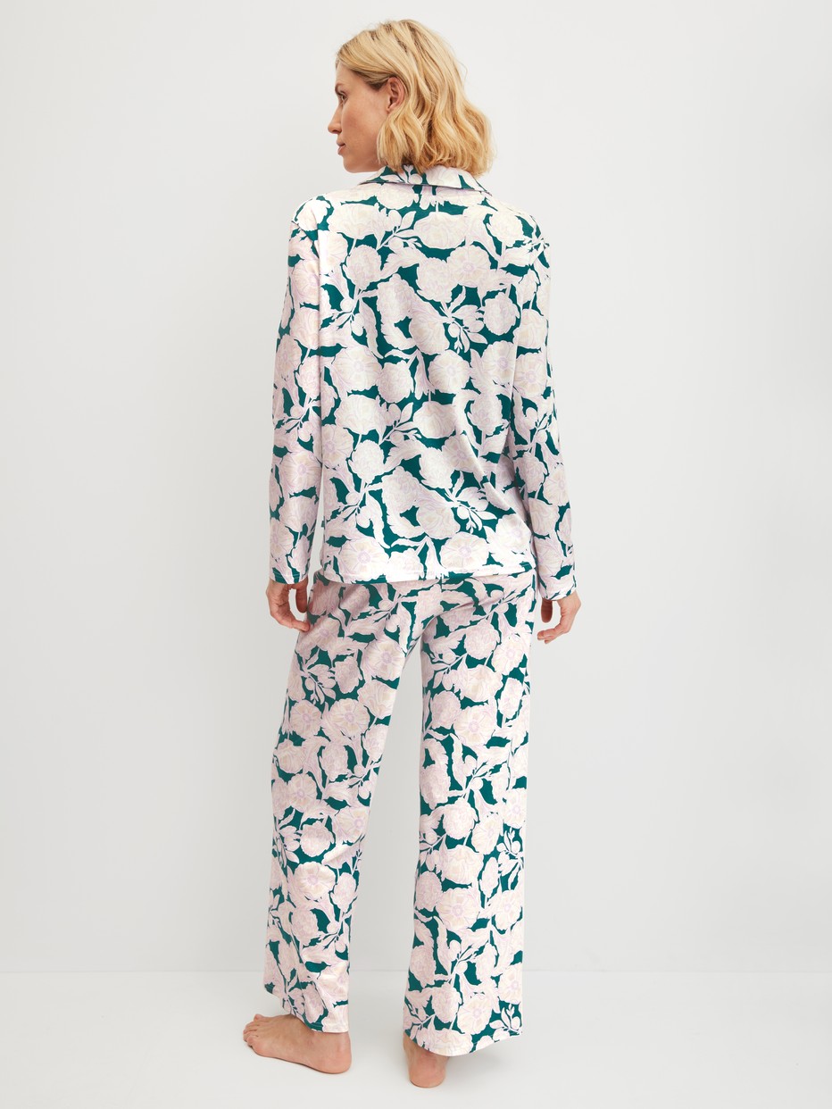 Women model is wearing Button-Up Pyjama made of 100% Cotton in Turquoise, Floral from the Botanic Dreams series by CALIDA, Back view
