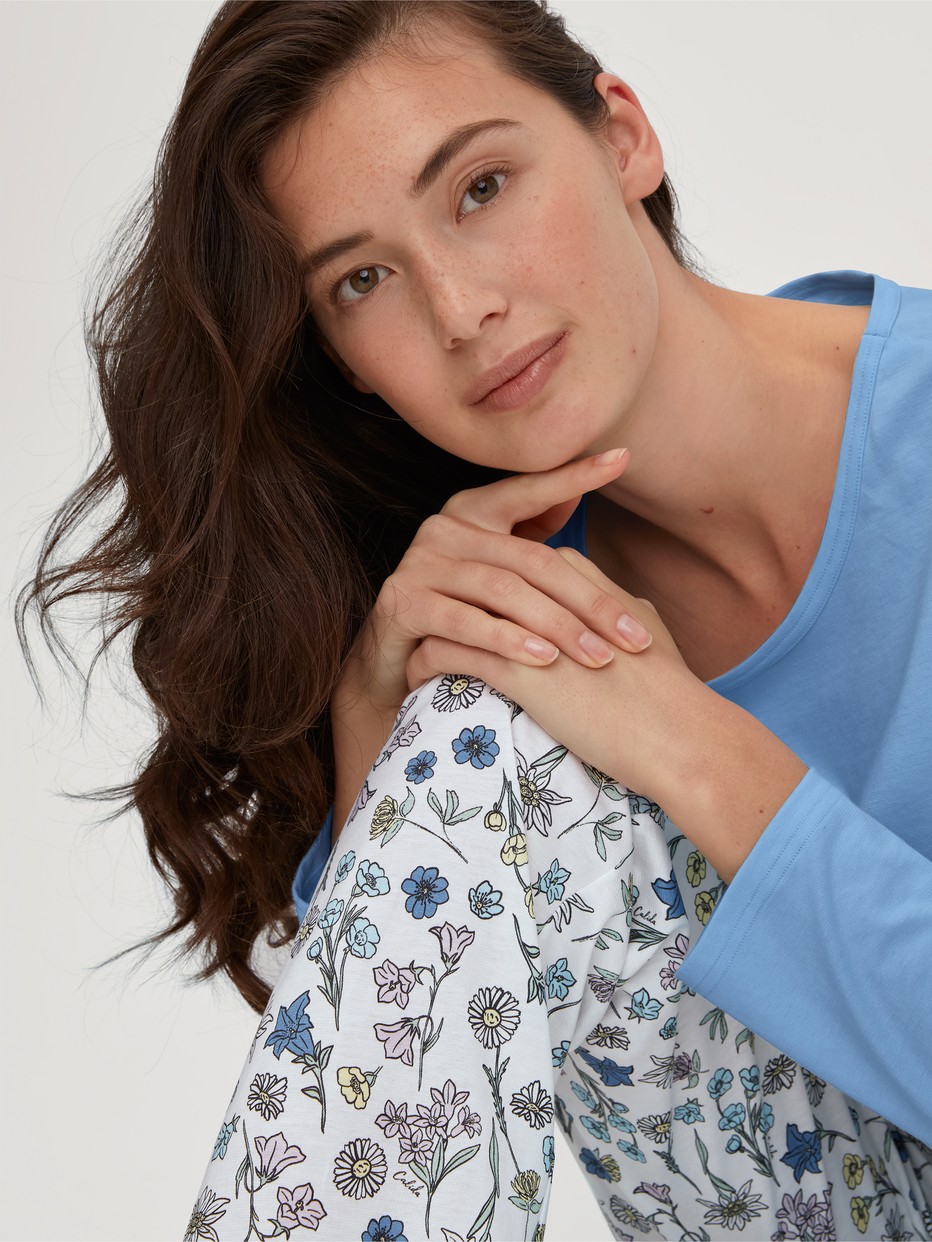 La modella / Il modello Donna indossa Pigiami, lunghi in 100% cotone di colore Blu, Floreale, della serie Flower Nights di CALIDA, Vista frontale