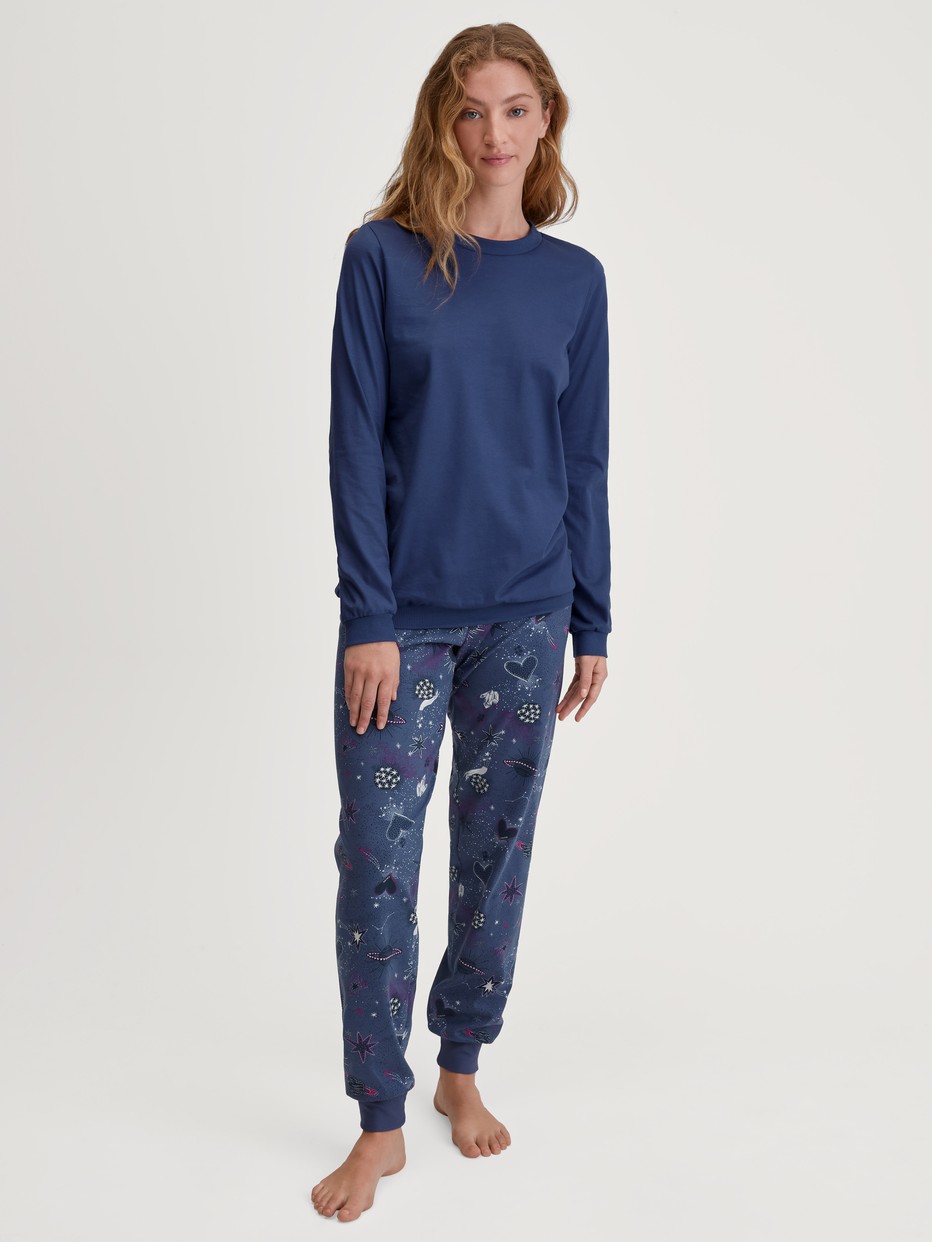Damen-Model trägt Bündchen-Pyjama aus 100% Baumwolle in Blau, Gemustert aus Serie Mystic Nights von CALIDA, Vorderansicht