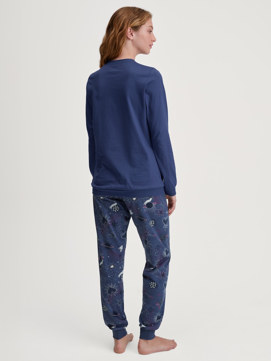Damen-Model trägt Bündchen-Pyjama aus 100% Baumwolle in Blau, Gemustert aus Serie Mystic Nights von CALIDA, Rückansicht