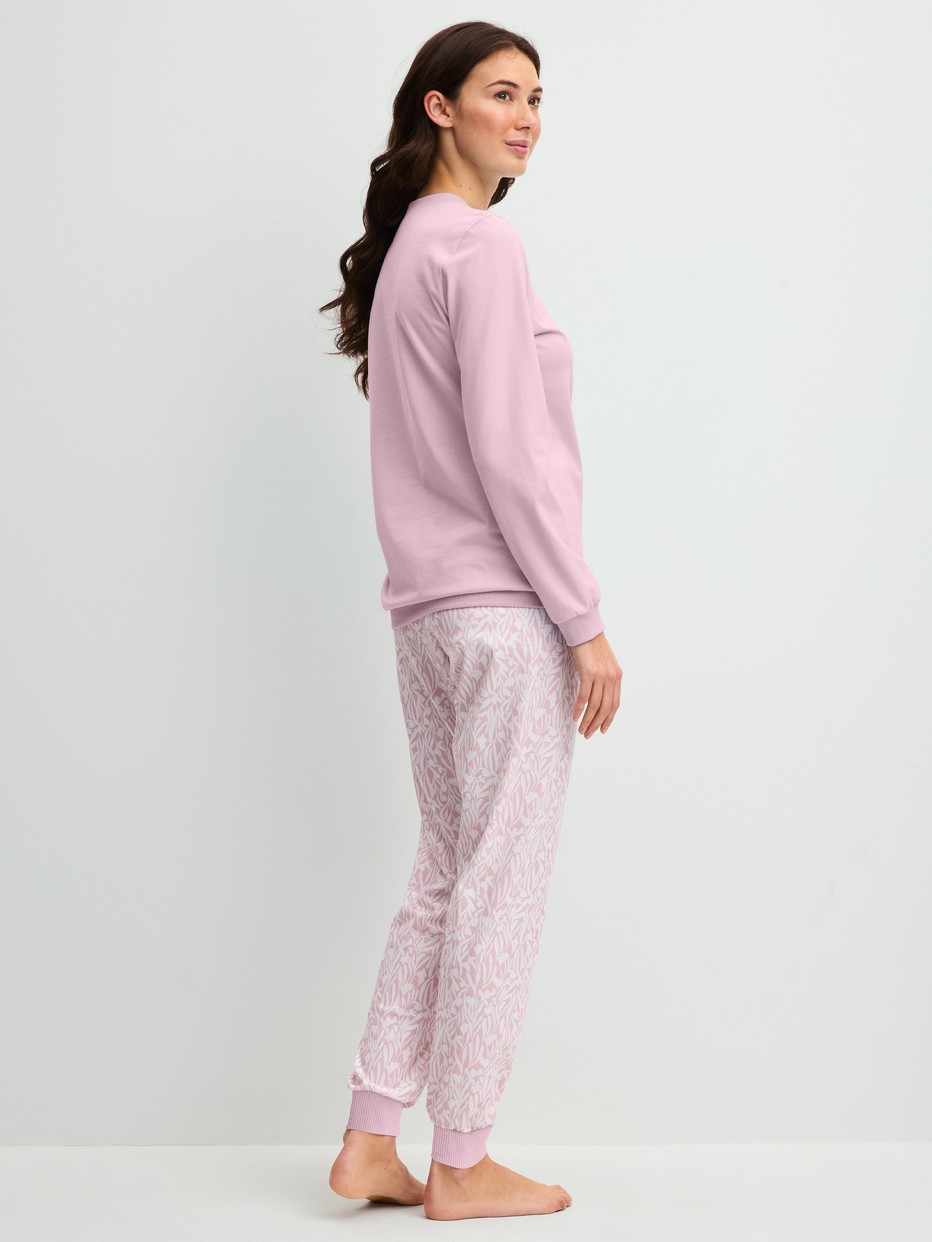 Damen-Model trägt Bündchen-Pyjama aus 100% Baumwolle in Violett, Gemustert aus Serie Blooming Nights von CALIDA, Rückansicht