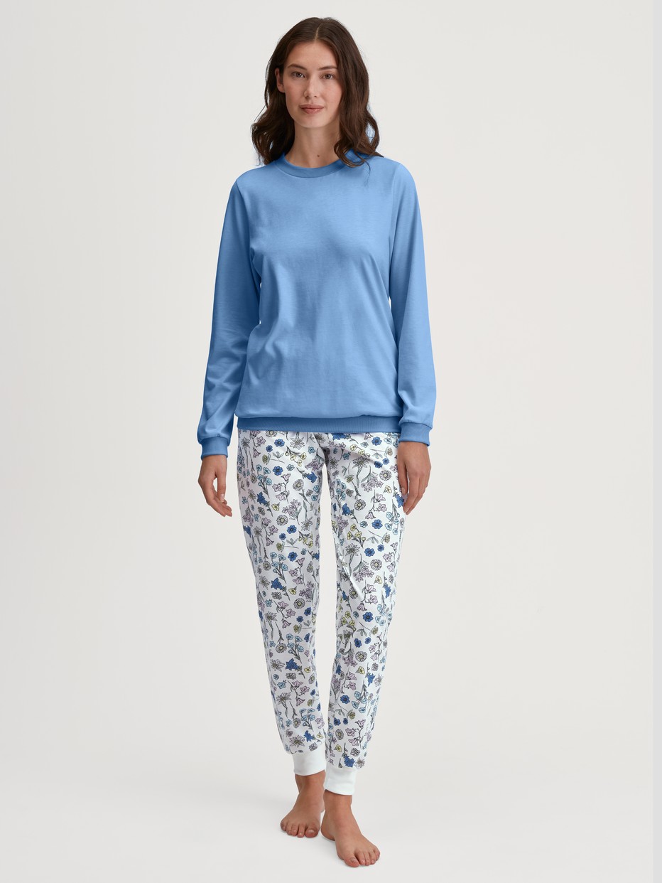Damen-Model trägt Bündchen-Pyjama aus 100% Baumwolle in Blau, Floral aus Serie Flower Nights von CALIDA, Vorderansicht