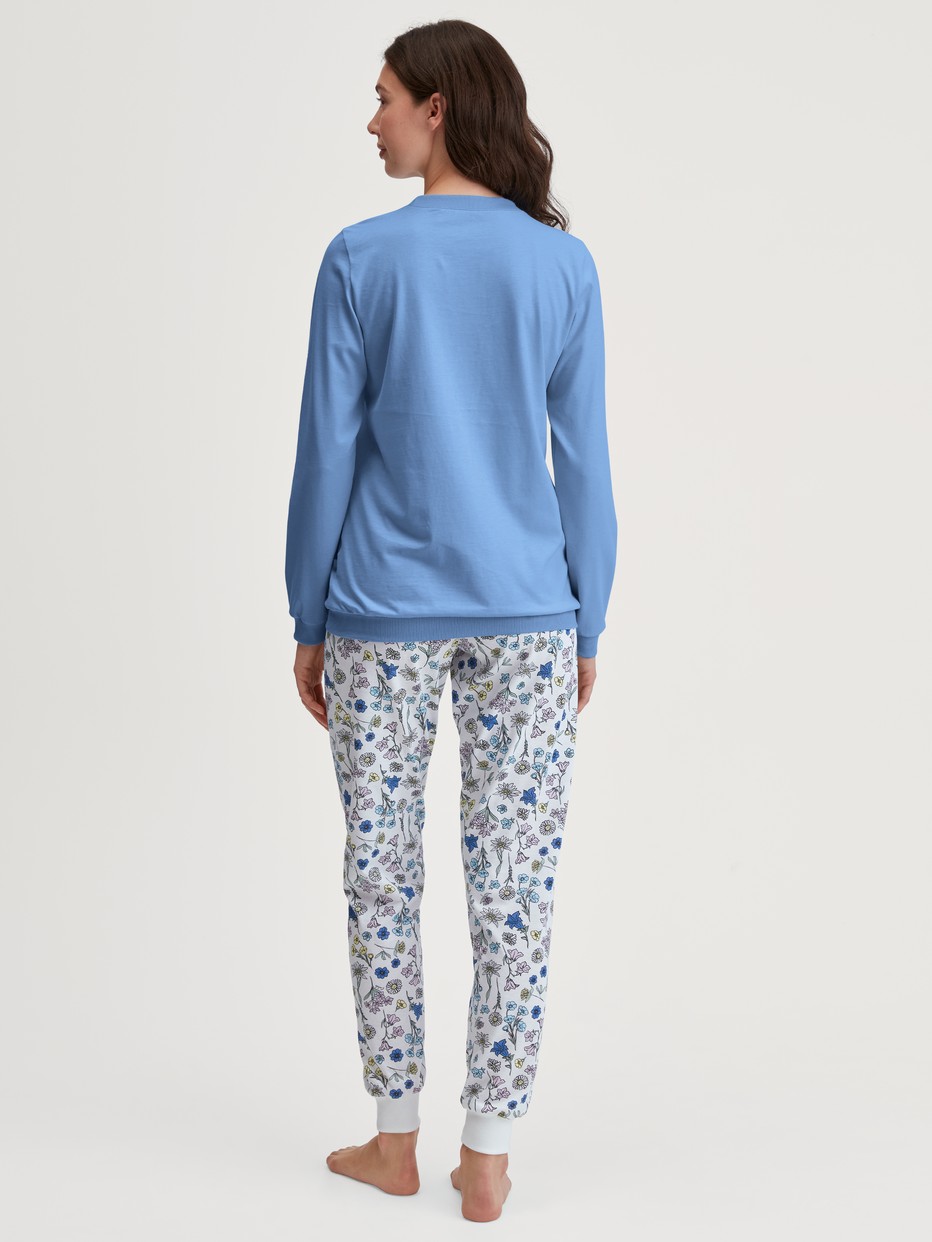 Damen-Model trägt Bündchen-Pyjama aus 100% Baumwolle in Blau, Floral aus Serie Flower Nights von CALIDA, Rückansicht
