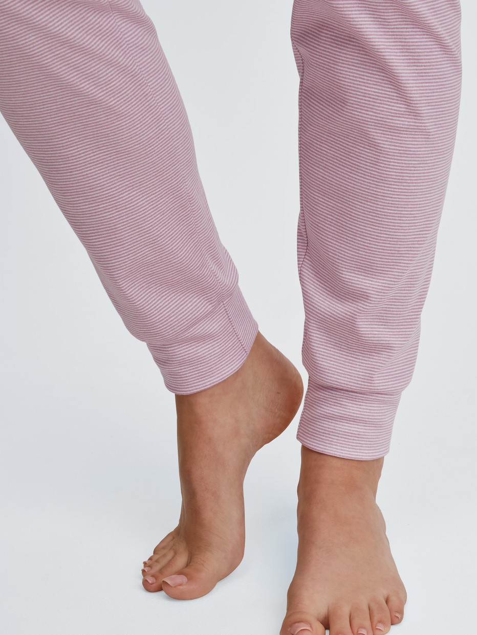 Damen-Model trägt Bündchen-Pyjama aus 100% Baumwolle in Rosa, Gestreift aus Serie Striped Dreams von CALIDA, Detail