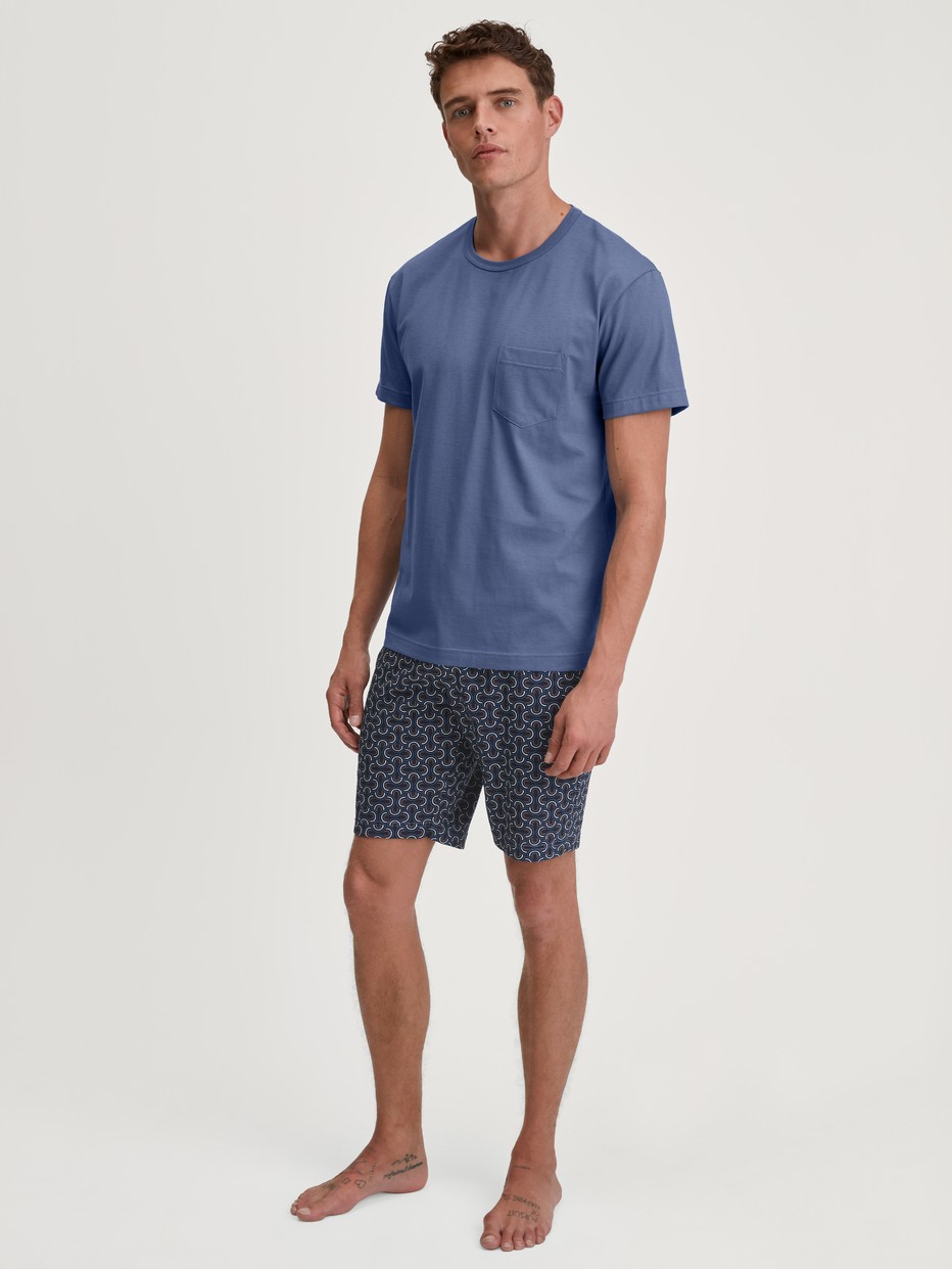 Herren-Model trägt Kurz-Pyjama aus 100% Baumwolle in Blau, Gemustert aus Serie Relax Imprint 1 von CALIDA, Vorderansicht