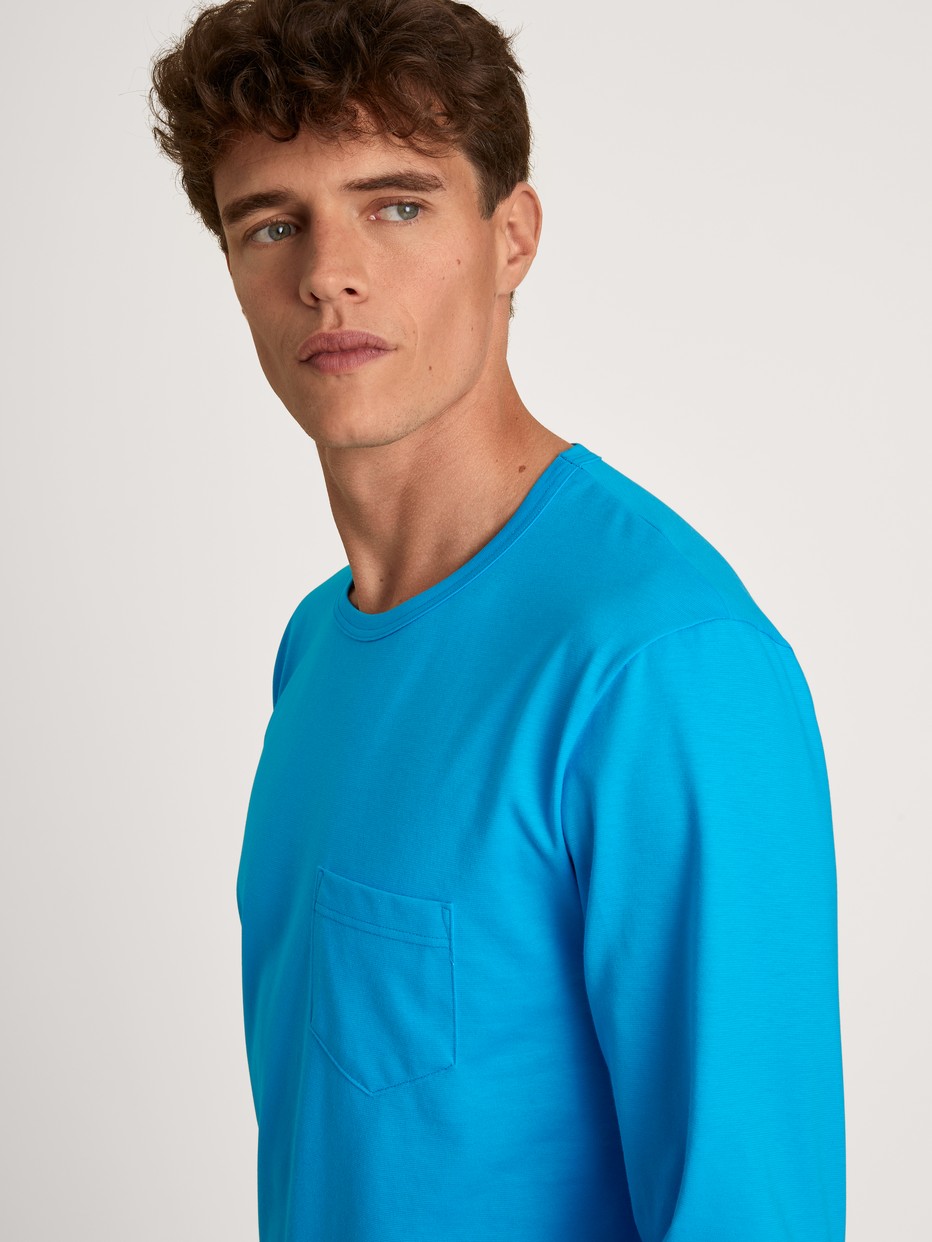 Herren-Model trägt Pyjama, lang aus 100% Baumwolle in Türkis, Motiv aus Serie Relax Imprint 1 von CALIDA, Detail