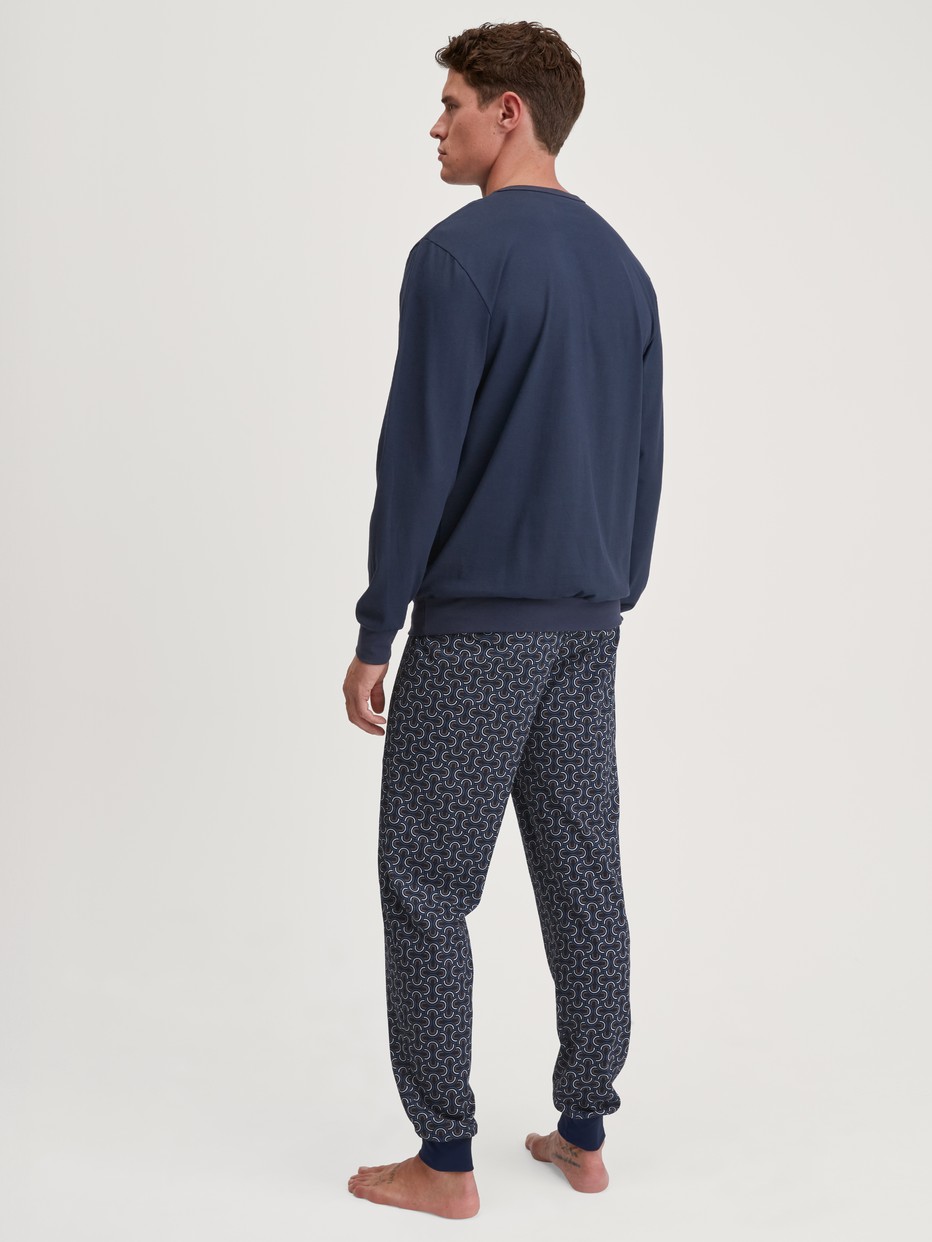 Herren-Model trägt Bündchen-Pyjama aus 100% Baumwolle in Blau, Gemustert aus Serie Relax Imprint 1 von CALIDA, Rückansicht
