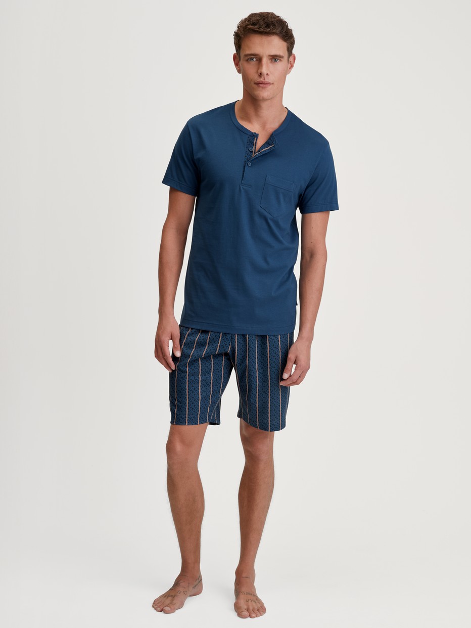 Herren-Model trägt Kurz-Pyjama aus 100% Baumwolle in Blau, Gestreift aus Serie Relax Imprint 1 von CALIDA, Vorderansicht