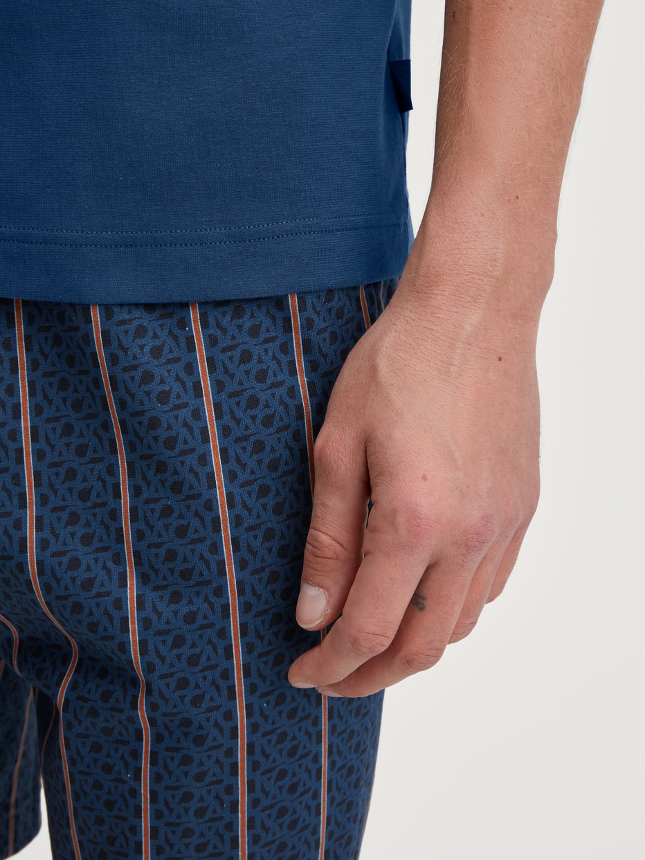 Herren-Model trägt Kurz-Pyjama aus 100% Baumwolle in Blau, Gestreift aus Serie Relax Imprint 1 von CALIDA, Detail