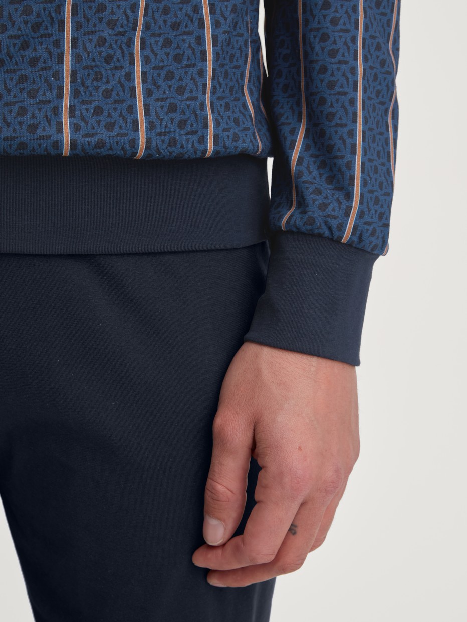 Herren-Model trägt Bündchen-Pyjama aus 100% Baumwolle in Blau, Gestreift aus Serie Relax Imprint 1 von CALIDA, Detail