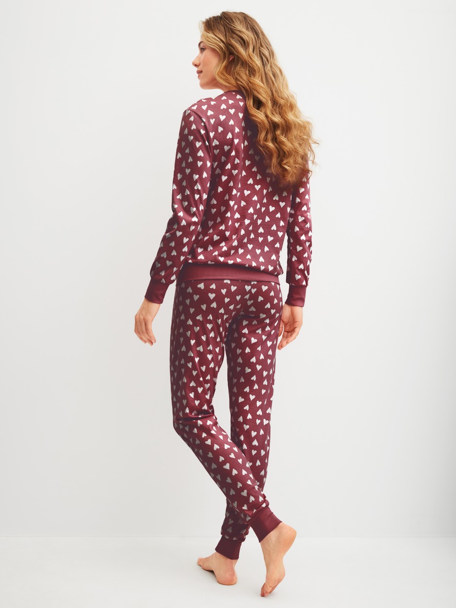 Damen-Model trägt Bündchen-Pyjama aus 100% Baumwolle in Rot, Einfarbig aus Serie Cotton Special von CALIDA, Rückansicht