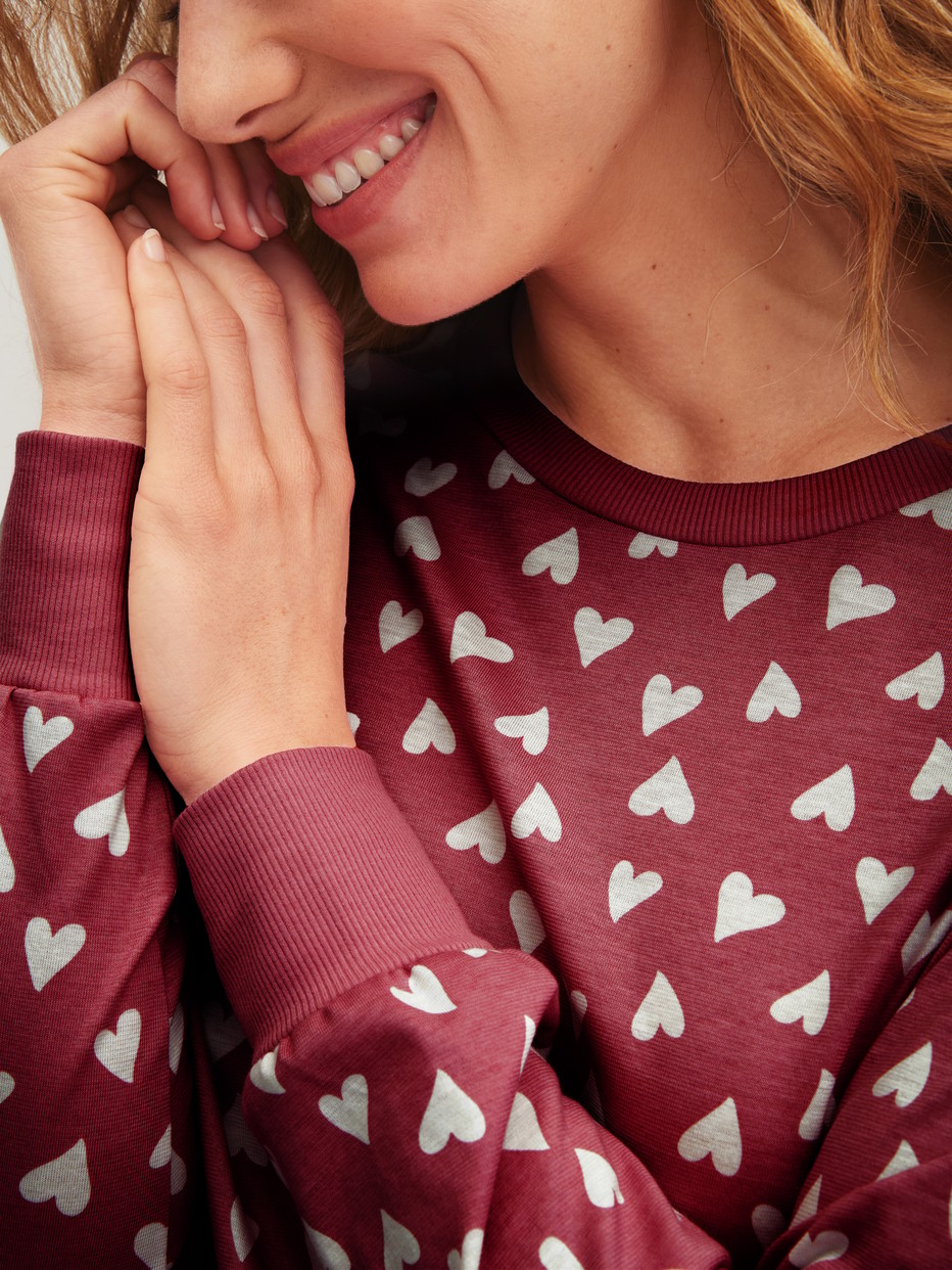 Damen-Model trägt Bündchen-Pyjama aus 100% Baumwolle in Rot, Einfarbig aus Serie Cotton Special von CALIDA, Detail